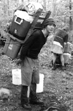 a packboard being used to carry cooler, tub and propane tank
